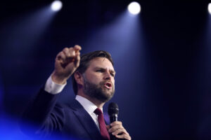 JD Vance speaking on stage at an event.