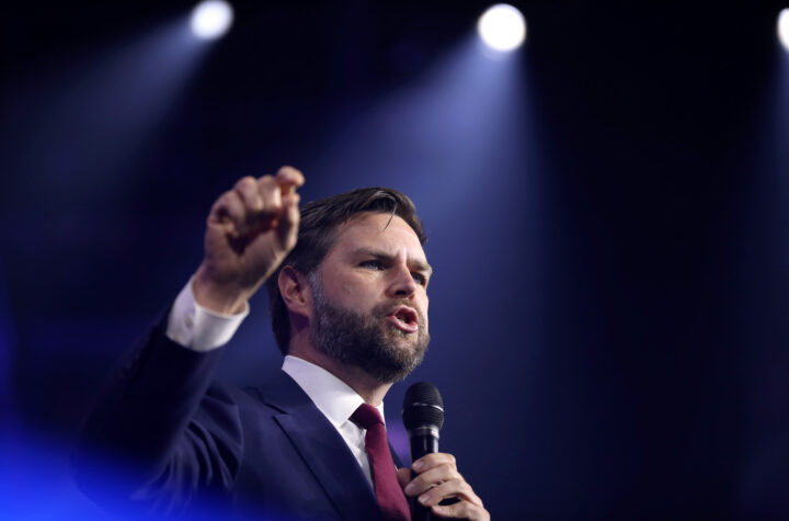 JD Vance speaking on stage at an event.